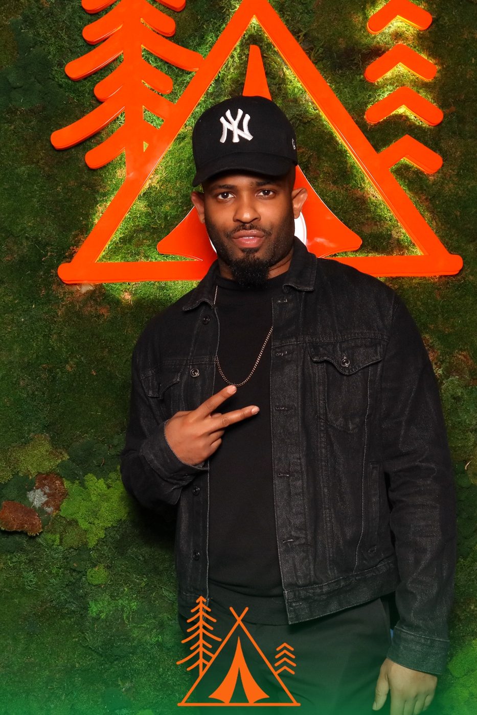 Trevor Queen in a cap and denim jacket at an outdoor activation