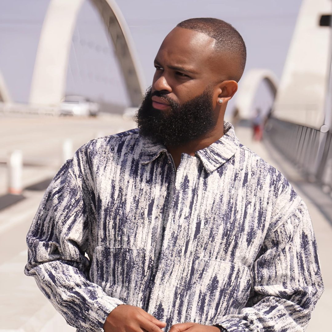 Trevor Queen in a monochrome marbled jacket, looking off camera