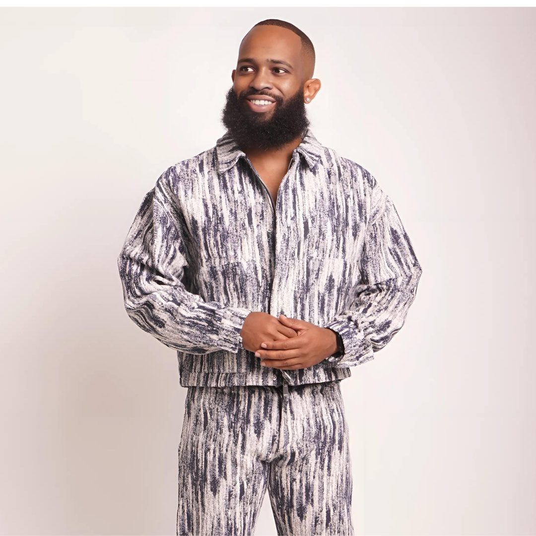 Trevor Queen in a monochrome marbled suit, hands together