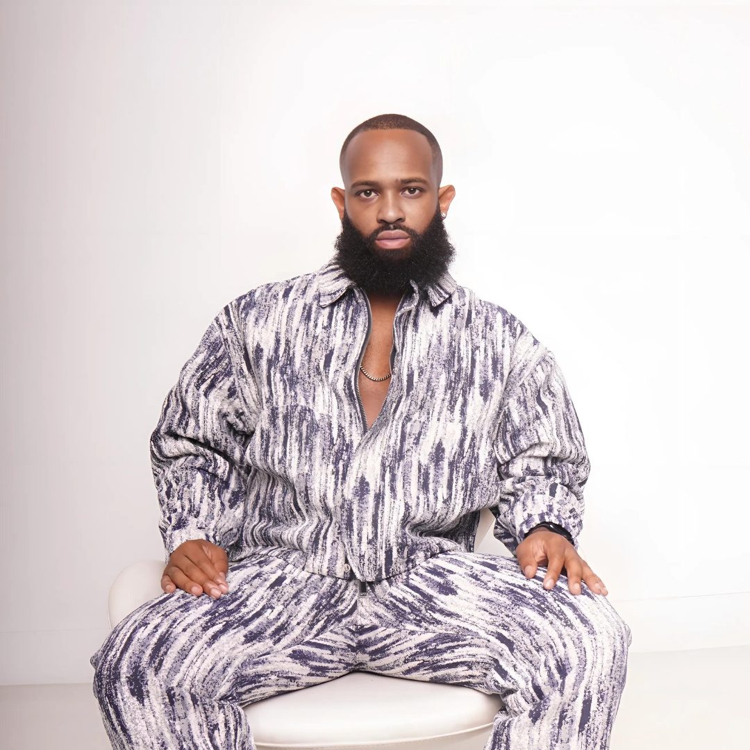 Trevor Queen seated in a monochrome marbled suit