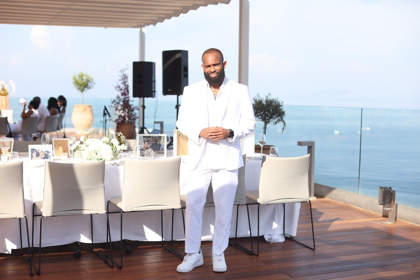 An oceanside event build with long tables set above the water